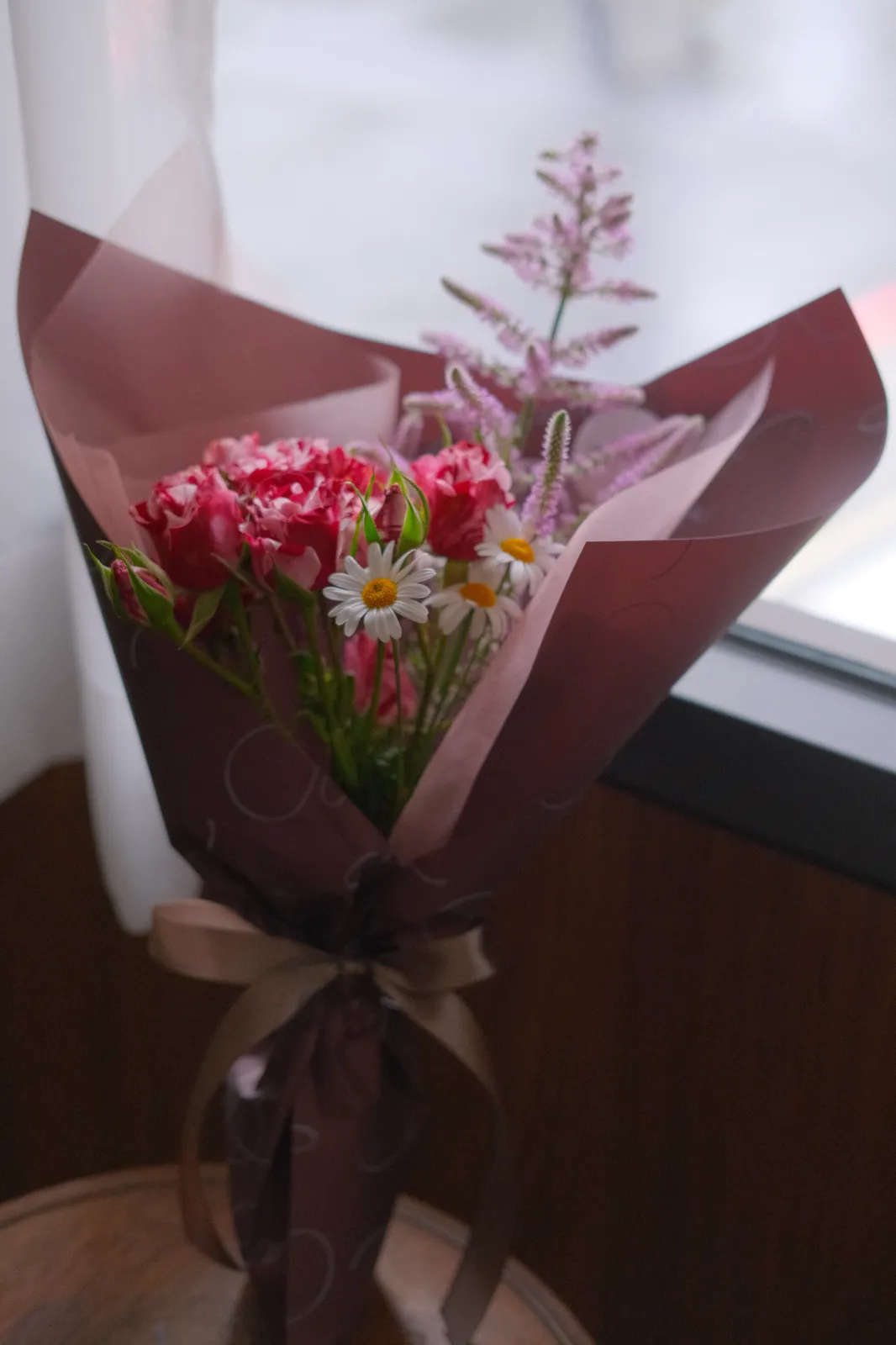 桃紅康乃馨花束，酒紅色包裝紙